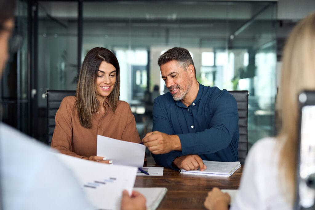Professional executive business group working with documents at office meeting. Wayfinder in-person comprehensive onboarding meeting